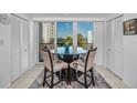 Bright dining area featuring a glass table, cushioned chairs, and sliding glass doors leading to a balcony with a view at 150 Belleview Blvd # 307, Belleair, FL 33756