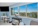 Bright living room featuring large windows offering views of the water, enhanced by stylish decor and ample natural light at 150 Belleview Blvd # 307, Belleair, FL 33756