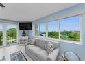Light and airy living room with a comfortable sofa, expansive windows and water views at 150 Belleview Blvd # 307, Belleair, FL 33756