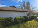 Lush green lawn with manicured bushes, complementing the clean white facade and dark roof at 1606 Comfy Ct, Sun City Center, FL 33573