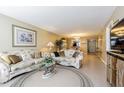 Spacious living room features a comfortable floral sofa, glass coffee table, and tile flooring at 1750 Belleair Forest Dr # A7, Belleair, FL 33756