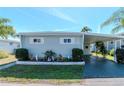 Charming single-story home with manicured landscaping, a covered carport, and tidy lawn at 18675 Us Highway 19 N # 251, Clearwater, FL 33764