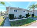 Well-maintained single-story home with tidy landscaping and a covered carport on a sunny day at 18675 Us Highway 19 N # 251, Clearwater, FL 33764