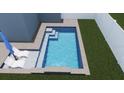 A refreshing backyard pool with a tanning ledge, accompanied by two lounge chairs and a blue umbrella at 2011 1St St, Indian Rocks Beach, FL 33785