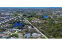 Aerial view of a neighborhood with homes near serene lakes and lush greenery at 2100 Mcmullen Rd, Largo, FL 33771