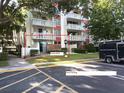 Exterior facade of Condo #103 with guest parking and mature tree in view at 2630 Pearce Dr # 103, Clearwater, FL 33764
