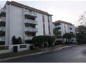 Exterior view of the building featuring multiple balconies and mature landscaping at 2630 Pearce Dr # 103, Clearwater, FL 33764