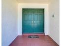 Inviting entryway featuring double doors, neutral wall color, terracotta tile flooring, and a welcome mat at 2725 Onizuka Ct, Palm Harbor, FL 34683