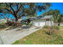 Traditional home featuring a two-car garage, a wide driveway, and mature trees providing shade at 3013 Ridgevale Cir, Valrico, FL 33596