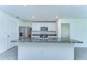 Bright kitchen showcasing a granite island countertop, stainless steel appliances, and modern white cabinets at 38255 Sonnet Landing Ave, Zephyrhills, FL 33540