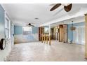 Renovated living room featuring an open layout, ceiling fans, and chandelier in a spacious setting at 411 Virginia Ave, Madeira Beach, FL 33708