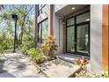 Townhome's entrance featuring a modern glass door and minimalist landscaping at 4156 Gauge Line Loop, Tampa, FL 33624