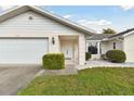 Close up of a one-story home featuring a two-car garage and landscaped yard at 4735 Foxshire Cir, Tampa, FL 33624