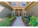 Charming townhome entrance with well-manicured hedges lining the walkway to the front door at 4739 Silverking Way, Palm Harbor, FL 34684