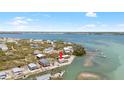 Aerial view of waterfront home on a beautiful day, surrounded by lush landscapes and blue waters at 9696 Little Gasparilla Isand, Placida, FL 33946