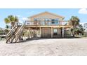 Charming elevated beach house featuring a spacious front deck, stairs, and beachfront access at 9696 Little Gasparilla Isand, Placida, FL 33946