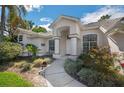 Welcoming front entrance with columns, arched windows, and colorful landscaping at 14472 Linden Dr, Spring Hill, FL 34609