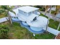 A unique modern home with a flat roof, multiple circular sections, and a well-manicured lawn at 1111 Dr M L King Jr N St, Safety Harbor, FL 34695
