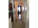 Bright hallway showcasing tile flooring, neutral wall paint, and doors leading to various rooms in the home at 15427 Bama Breeze Pl, Wimauma, FL 33598