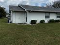 Home exterior showcasing manicured lawn, side entrance and air conditioning unit at 2233 Greenhaven Dr # 363, Sun City Center, FL 33573