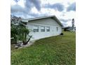 Well-maintained home exterior featuring a lush green lawn and vibrant palm trees at 2233 Greenhaven Dr # 363, Sun City Center, FL 33573