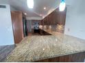 Spacious kitchen boasting granite countertops, wooden cabinets, and modern lighting fixtures at 250 Rosery Nw Rd # 220, Largo, FL 33770