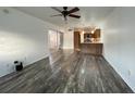 Living room featuring hardwood floors and a ceiling fan connecting to the kitchen and sliding door at 250 Rosery Nw Rd # 220, Largo, FL 33770