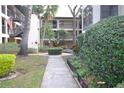 Exterior view of building and landscaped walkway with black fencing at 3399 Mermoor Dr # 110, Palm Harbor, FL 34685
