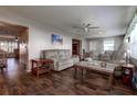 Cozy living room with ceiling fan, wood-look flooring, and comfortable seating at 3550 100Th N Pl, Pinellas Park, FL 33782