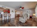 Inviting living room with dark floors, ceiling fan, breakfast bar, and neutral decor at 3550 100Th N Pl, Pinellas Park, FL 33782