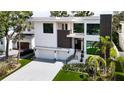 View of modern two-story home featuring a three-car garage and manicured landscaping at 4816 W San Jose St, Tampa, FL 33629