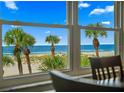 Stunning ocean view from a large window, showcasing palm trees and white sand at 5000 Gulf Blvd # 304, St Pete Beach, FL 33706