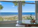 Lovely ocean view from a window, overlooking the beach and palm trees at 5000 Gulf Blvd # 304, St Pete Beach, FL 33706