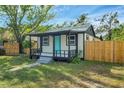 Cute single-story home with a small porch, tidy lawn, and wooden fence at 8308 N Mulberry St, Tampa, FL 33604