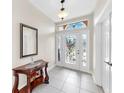 Bright foyer with decorative glass front door, stylish console table and tile flooring at 8436 White Poplar Dr, Riverview, FL 33578