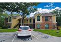 Exterior of tan and brick condo complex featuring car parking with assigned numbered spaces at 8642 Mallard Reserve Dr # 203, Tampa, FL 33614