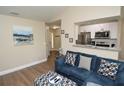 Comfortable living room with blue sofa, wood floors, open to kitchen, and neutral walls at 8642 Mallard Reserve Dr # 203, Tampa, FL 33614
