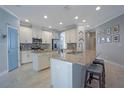 Spacious kitchen featuring granite countertops, an island with seating, stainless steel appliances, and stylish backsplash at 8765 Sentiero Dr, Land O Lakes, FL 34637