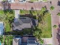 Detailed aerial view of a home surrounded by lush lawns, palm trees, and classic brick streets at 100 Buena Vista S Dr, Dunedin, FL 34698