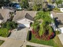 An aerial view showcases a charming single-Gathering home with mature landscaping, a two-car garage, and nearby street at 11218 Longbrooke Dr, Riverview, FL 33579