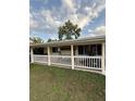 Inviting front porch with white railing and comfortable swing for relaxation at 1149 6Th Ne Ave, Largo, FL 33770