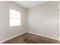 Simple bedroom with neutral-toned walls, carpeted flooring, and a bright window at 1322 E Ohio St, Plant City, FL 33563