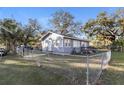 Cozy one-story home featuring a fenced yard, manicured lawn, and a welcoming facade at 1322 E Ohio St, Plant City, FL 33563