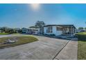 Well-maintained single-story home with covered parking, ramp access, and a decorative front bench at 196 Philadelphia Blvd # 10, Palm Harbor, FL 34684