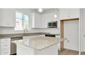 Modern kitchen with white cabinets, granite countertops, and stainless steel appliances at 31869 Anchor Point Dr, Wesley Chapel, FL 33545
