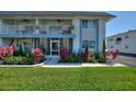The exterior of a condominium features bright landscaping, a white balcony, and large windows at 4400 37Th S St # 2, St Petersburg, FL 33711