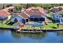 Waterfront home featuring a screened-in patio, swimming pool, wooden deck, and private boat dock for relaxing waterfront living at 6014 Mariners Watch Dr, Tampa, FL 33615