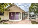 An outdoor view of a property with a rounded room, patio with a pool, and surrounding brick floor at 7124 Jasmin Dr, New Port Richey, FL 34652