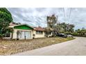 A charming single-story home with a green awning, sliding glass door, and well-manicured lawn at 7124 Jasmin Dr, New Port Richey, FL 34652