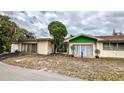 A single-story home featuring sliding glass doors and a green awning, offering a cozy curb appeal at 7124 Jasmin Dr, New Port Richey, FL 34652